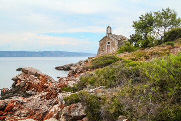 Beautiful little abandoned chapel at the coast of Hvar island - obrazy, fototapety, plakaty
