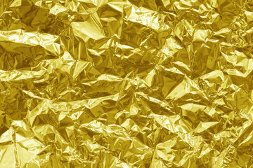 Shiny gold foil texture background, pattern of yellow wrapping paper with crumpled and wavy.