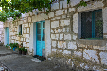 A typical old country stone house with turquoise doors in Croatia