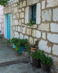 Flower pots in a row in front of an old stone wall, rural scene