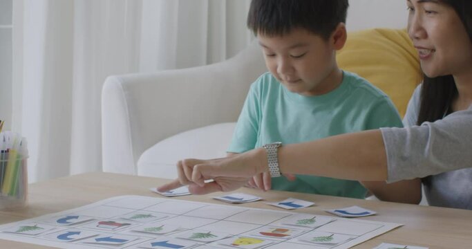 Little cute boy son enjoy fun learn offline class computer language game Unplugged Coding computing STEM STEAM with mom. Asia pupil kindergarten gen Z smart small kids smile play at table home sofa.