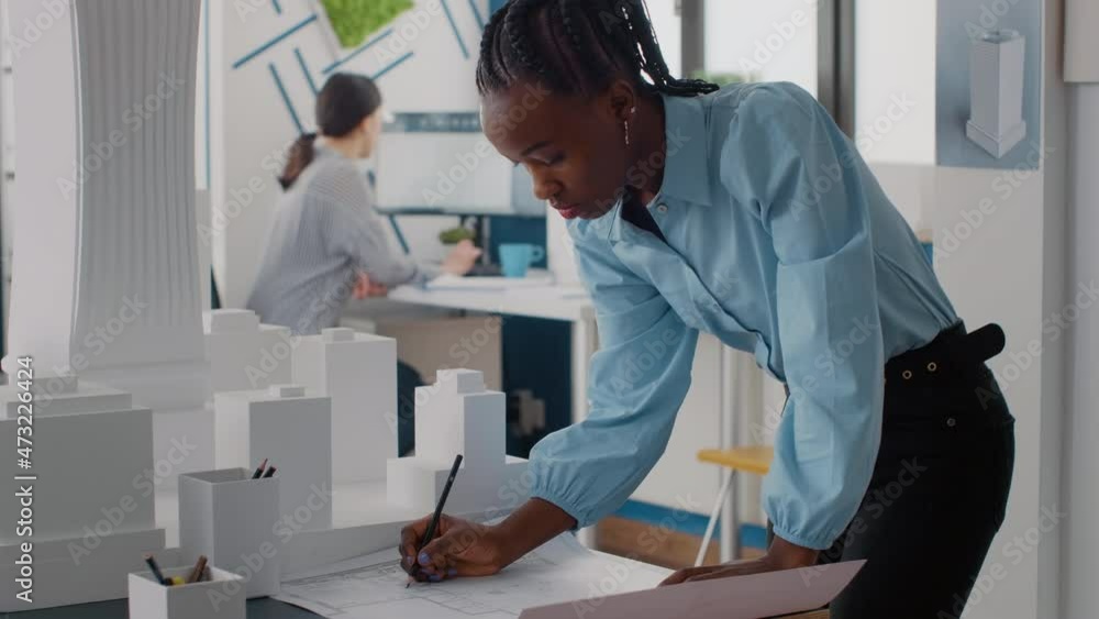 Poster woman engineer looking at blueprints plans on table to design construction layout. expert architect 
