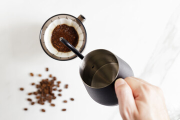 Hand drip coffee with beans on white table background.