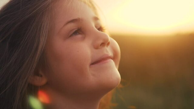 happy little girl child look up dreams. kid wants a dream come true portrait at sunset. baby daughter silhouette dreaming of a happy childhood. free face sister side view thinks lifestyle. concept