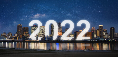 New Year 2022 in the city. Panoramic city at night with starry sky and happy new year 2022...