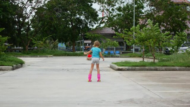 8-year-old girl roller skating in the parking lot