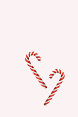 Red colored,striped two candy canes on white surface,This illustration can be used vertically or horizontally.