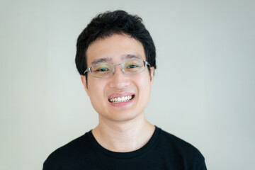 Handsome - happy Asian young man with eye glasses in black shirt portrait.
