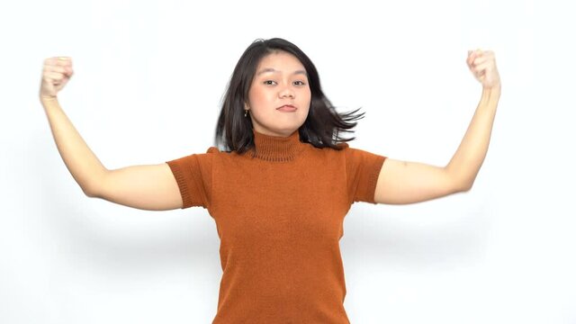 Showing strength and rise arms of Beautiful Asian Woman Wearing Orange T-Shirt Isolated On White Background