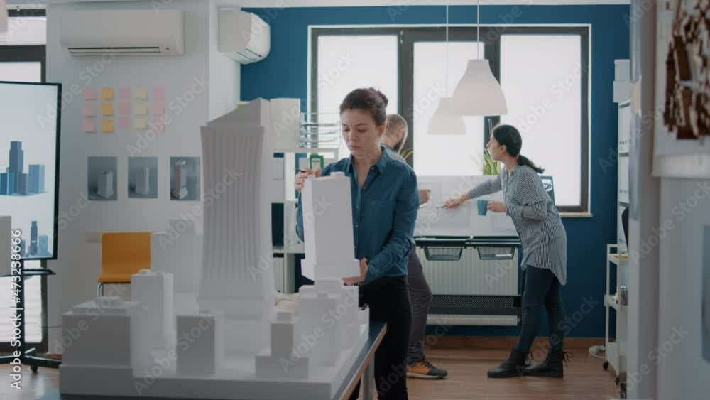 Poster portrait of employee working with building model and maquette to design blueprint plan for urban con