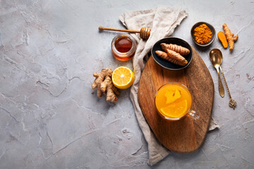 Fototapeta na wymiar Healthy turmeric golden tea on light gray background.