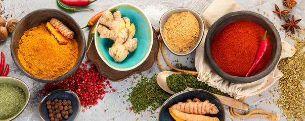 Assortment of Indian spices on gray background.