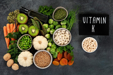 Foods high in vitamin K on dark background.