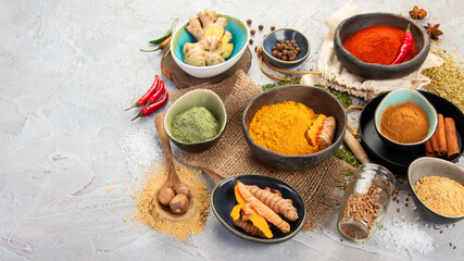 Assortment of Indian spices on gray background.
