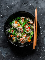 Basmati rice with shrimp and vegetables in asian style on a dark background, top view