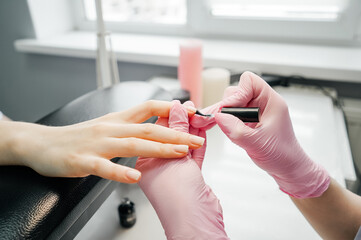 Side view of process of manicure, salon.