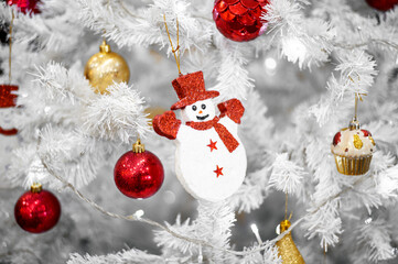 White Christmas tree decoration with red balls on fir branches