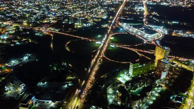Aerial time-lapse view of traffic at night in Accra, Ghana drone slide pan up