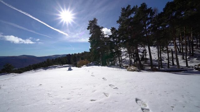 Man contemplating the mountainous landscape from the top of a snowy hill. Guadarrama Madrid.
