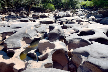 The pits in the rocks along the rivers are formed by geological nature.