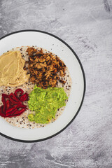 plant-based food, vegan version of the viral layered tortilla wrap hack with red peppers hummus avocado and shredded teriyaki tofu