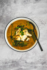 vegan yellow cauliflower curry with carrots celeri and parsley, healthy plant-based food