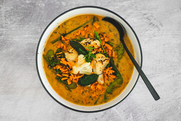 vegan yellow cauliflower curry with carrots celeri and parsley, healthy plant-based food