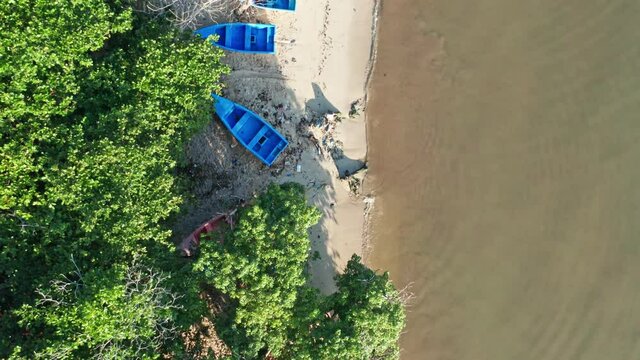 Aerial top-down forward over wooden fishing boats moored on beach, Barahona in Dominican Republic