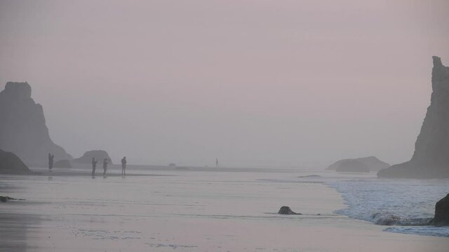 Tourist family taking pictures in the mist on an Oregon Beach