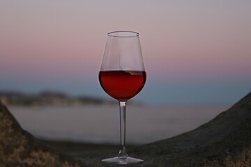 glass of red wine on the beach