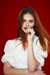 cheerful red-haired woman with red lips white dress red background