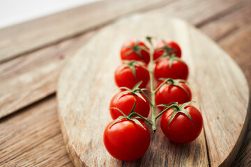 cherry tomatoes on a branch on a wooden board kitchen ingredient fresh food