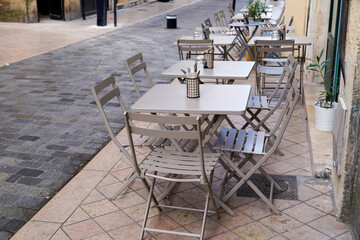 Fototapeta na wymiar steel gray chairs on cafe outdoor restaurant cafe and metal tables grey metalic silver terrace