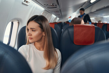 Young passenger looking out of window of plane