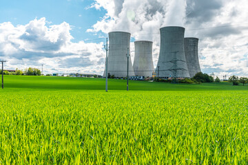 Cooling tower of nuclear power plant behind green grass. Atomic energy. Nuclear power and the...