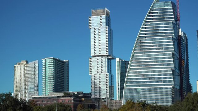 Zoom in shot of luxury high-rise apartment and new google building during sunlight and blue sky - Austin,Texas