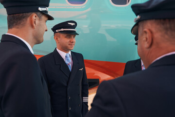 Young pilot listening to other people during group conversation © Viacheslav Yakobchuk