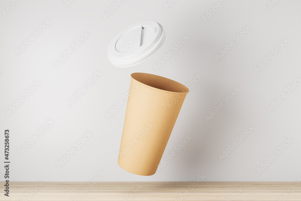 Poster empty yellow take away coffee cup on white background and wooden surface. advertisement and mock up 