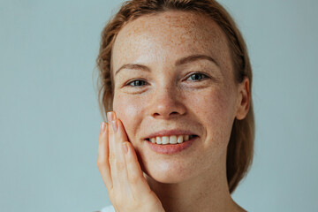 Beautiful woman with read hair and freckles. Close up portrait against black background
