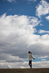 秋の公園でヨガを練習している若い女性ヨガインストラクターの姿と綺麗な青空の風景
