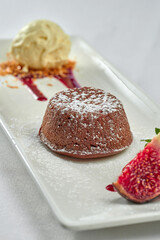 Dessert chocolate fondant with ice cream in a white plate on a white plate