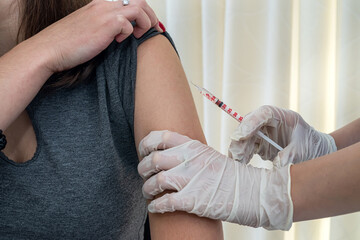 young nurse doing coronavirus vaccination in hospital.