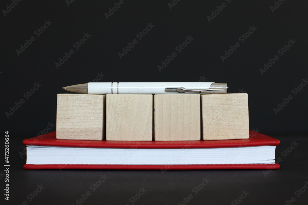 Poster four wooden blocks on the table with notepad and pen, template