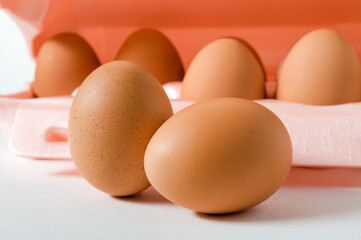 A few raw chicken eggs and its packaging