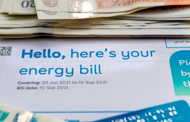 An energy bill with bank notes and payment card. Energy cost concept.