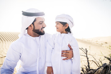 Arabian man and son playing in the desert