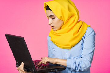 cheerful muslim woman in yellow hijab learning laptop technology