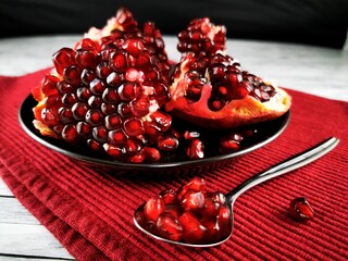 Pomegranate fruit.  Pomegranate fruit and spoon full of fresh ripe pomegranate. 