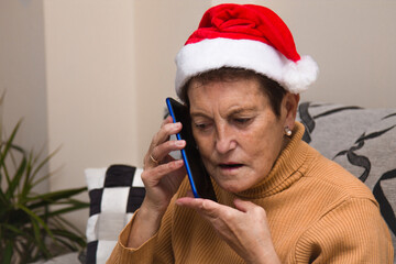 senior woman with christmas santa hat using mobile phone
