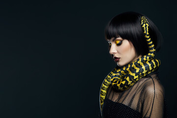 Beauty woman short haircut python yellow snake on her neck. A yellow snake on the shoulders of a...